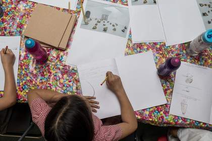 An overhead shot of a young person writing in their notebook.