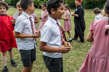 Lyndsey and the students walk in a circle, holding their vessels, smiling laughing and speaking to each other.