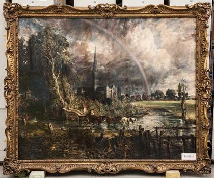 The frame surrounding the work has long scrolling curves, with sections of more ornate, foliage-like decoration on the corners and the middle of each edge. Its colour is a dull bronze.