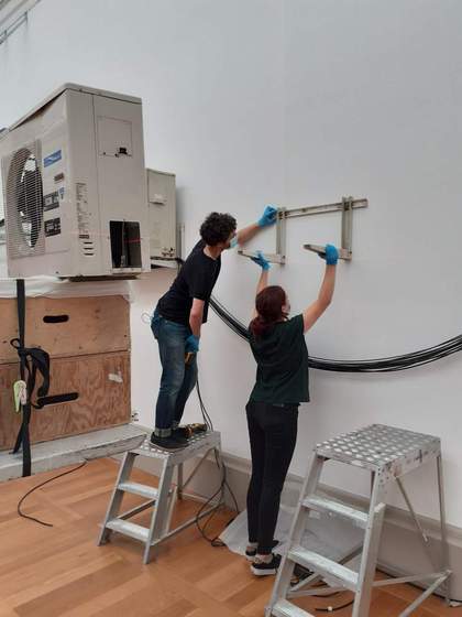 Art handling technicians fitting wall brackets to an installation