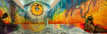 Three large walls painted with red, yellow and blue mural featuring three dark skinned figures