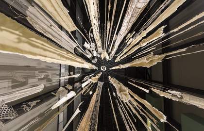 The perspective of standing in the middle of Cecilia Vicuna's Brain Forest Quipu Turbine Hall Commission, looking directly up so that the strands of material stretch out to the sides of the frame.