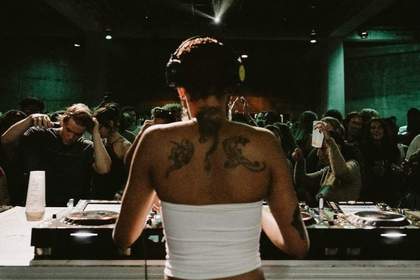 The back of a DJ looking out onto a crowd