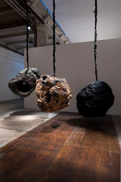 Three large circular object hanging from thick rope or twine from the ceiling