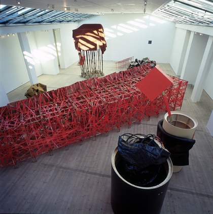 A view from above of the installation, the main object being a large red fretwork object
