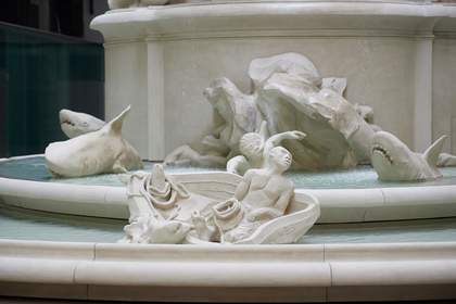 detail of fountain sculpture showing sharks lurking and a man in a a boat.