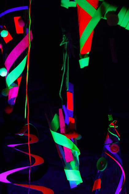 Dark image with bright neon lights of people in the Drawing Disco