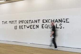A man walks past a display with the words 'The most important exchange is between equals'