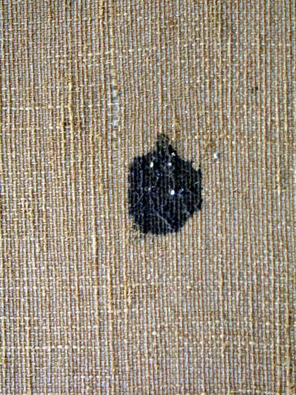 Detail of black stain on reverse of canvas where paint has seeped through