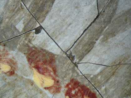 Fig.19 Detail at x16 magnification of two tiny losses of paint in the white sleeve, showing dark grey dead colouring underneath