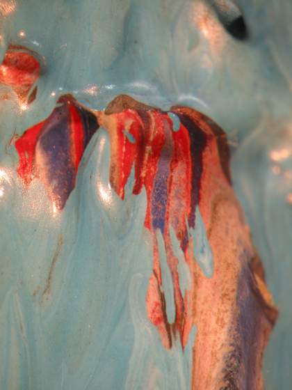 Micrograph showing multi-coloured paint beneath the blue