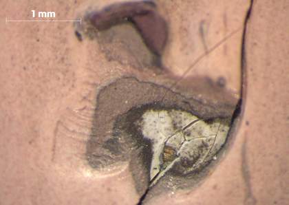 Paint loss in the straight leg of the left figure, showing a layer structure including pink flesh colour