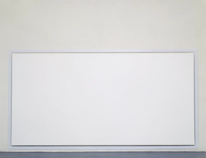 A photograph of a large white canvas hanging just off the floor in a gallery space.