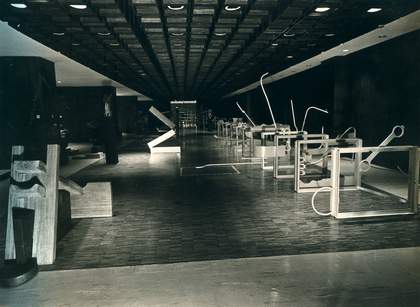 Black-and-white photograph of a large exhibition hall, with Roberto Chabet’s Hurdling 1970, a series of vertically suspended frames (a reference to athletic hurdles) from which stem jagged protrusions made of found scraps of metal