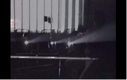 Still from Tyler Hubby’s film of the performance of Ten Years Alive at the Empty Bottle, Chicago, 1996, showing the projector
