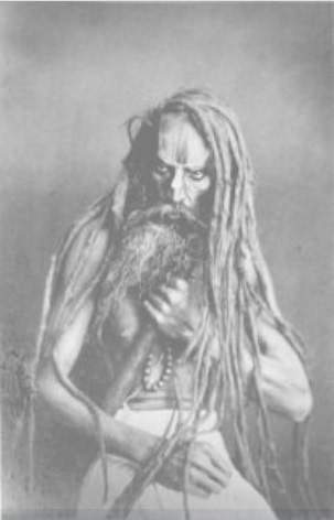 A portrait of a figure with long hair and a long beard, grasping a pole-like object and some beads against their chest.