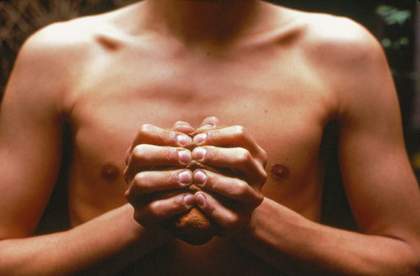 Gabriel Orozco My Hands Are my Heart 1991 photograph of a mans bear chest with his hands squeezing a peice of clay