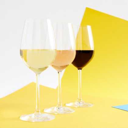 Photograph of three full wine glasses showing the house range of rose, white and red.