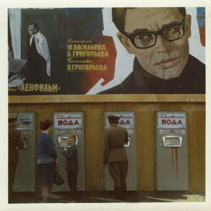 Mineral water vending machines, Moscow, 1970. The film poster above the machines is advertising Castling on the Long Side (Rokirovka v dlinnuiu storonu) 1969, directed by Vladimir Grigoriev, which starred Aleksandr Demyanenko