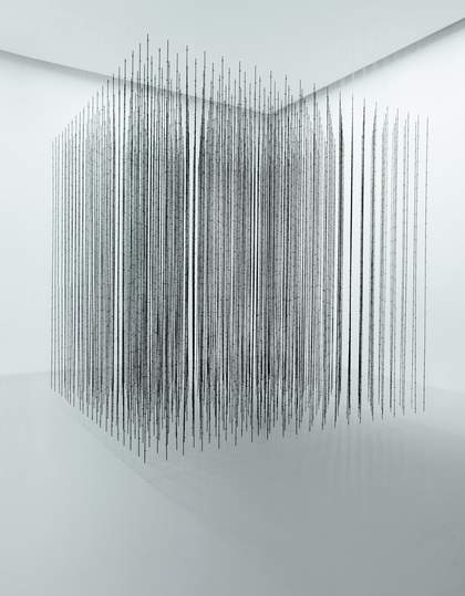 A white room with a floating cube in the centre made up of black wire pieces