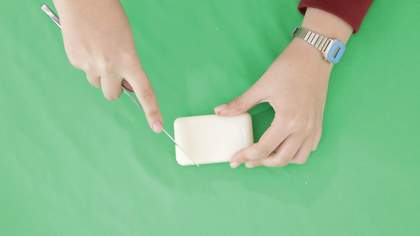 Photograph of hands carving soap