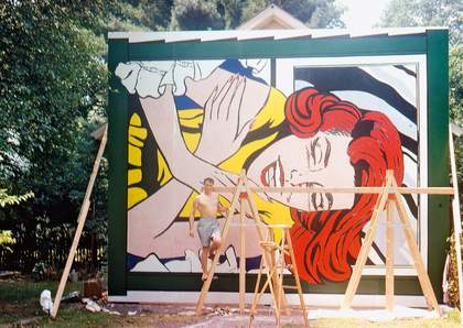 Roy Lichtenstein poses for the camera in front of Girl at Window (1964), made for the New York World's Fair, Flushing Meadows
