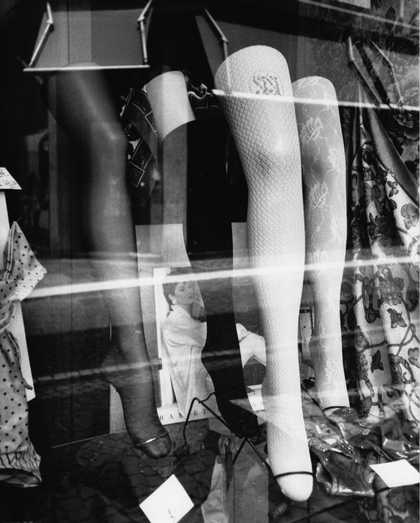 A black-and-white image of women's hosiery displayed in a shop window