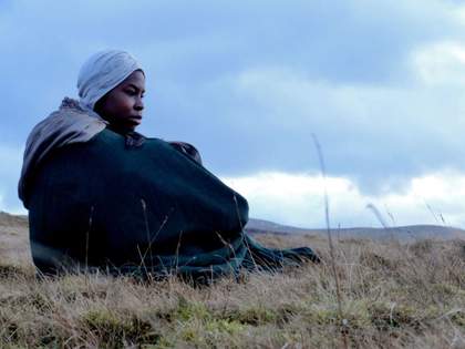 Young black person sat on a hill