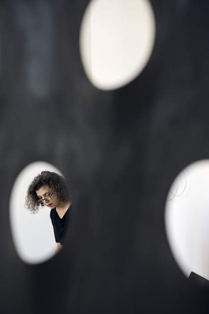 The artist seen through a hole in her work