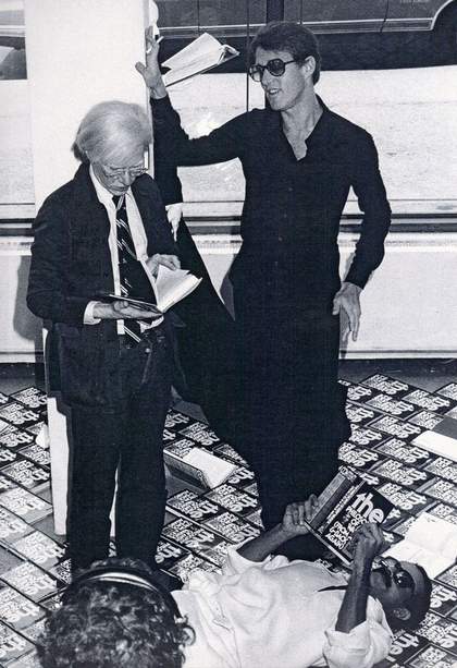Andy Warhol with Halston in a window display for his book 'The Philosophy of Andy Warhol (From A to B and Back Again)', 1975