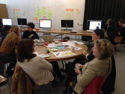 People sitting around a table covered in paper and notes