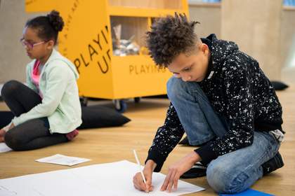 Two kids drawing on the floor 