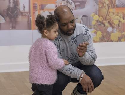 Father and daughter looking at a scrap of paper together
