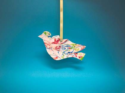 bird made from marbled paper hanging on a ribbon 