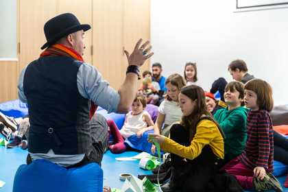 man in bowler hat telling a story to kids 