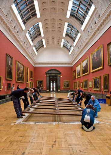 The stretcher being placed on top of the unrolled canvas. 