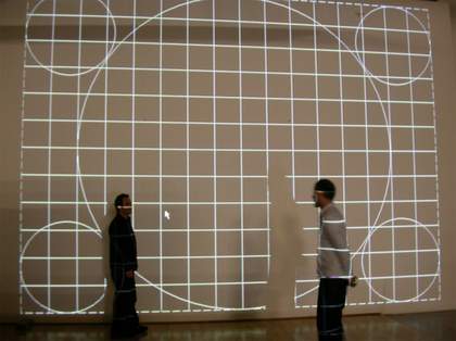 Two people stand in front of a projected wall