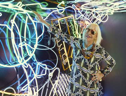 The artist Marta Minujín poses with a neon artwork in in Menesunda Reloaded at the New Museum in New York 2019